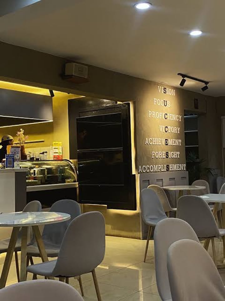 The Dr. Coffee counter and pastry case, beside a wall lettered with the brand's principles