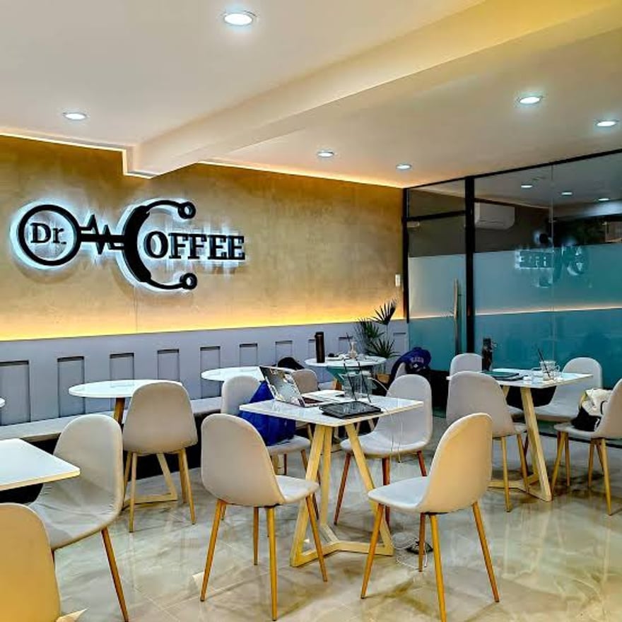 The Dr. Coffee dining room, with the illuminated logo mounted on a warm-lit feature wall